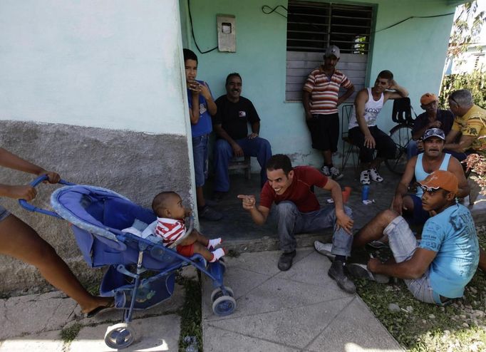 Luis Salgado (C, red shirt), nicknamed Chucho, spends time with family and friends at their home in the village of Sagua La Grande in central Cuba, March 10, 2013. Chucho was granted a U.S. visa based on his father's status as legal resident in Texas, and he was reunited in Miami with his father, Jesus Salgado, who had escaped Cuba on a frail boat ten years earlier. The Salgados are among many Cubans taking advantage of Cuba's new travel policy in place since last January, which allows citizens to leave the country with just a passport and no need for much-hated exit visas required since 1961. Picture taken March 10, 2013. REUTERS/Desmond Boylan (CUBA - Tags: POLITICS SOCIETY) Published: Dub. 11, 2013, 2:04 odp.