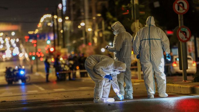 Forenzní specialisté zkoumají místo výbuchu bomby u kanceláří Hellenic Train v Aténách v Řecku.
