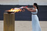 "Vrchní kněžka" zapaluje olympijskou pochodeň.