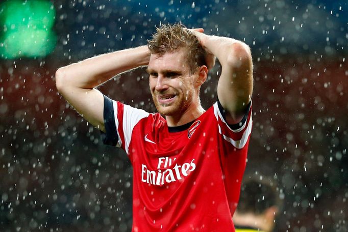 Per Mertesacker smutní po porážce Arsenalu v Lize mistrů s Dortmundem