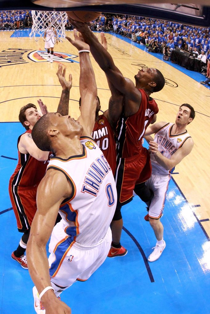 Russell Westbrook (vlevo) a Chris Bosh se přetahují pod košem o míč.