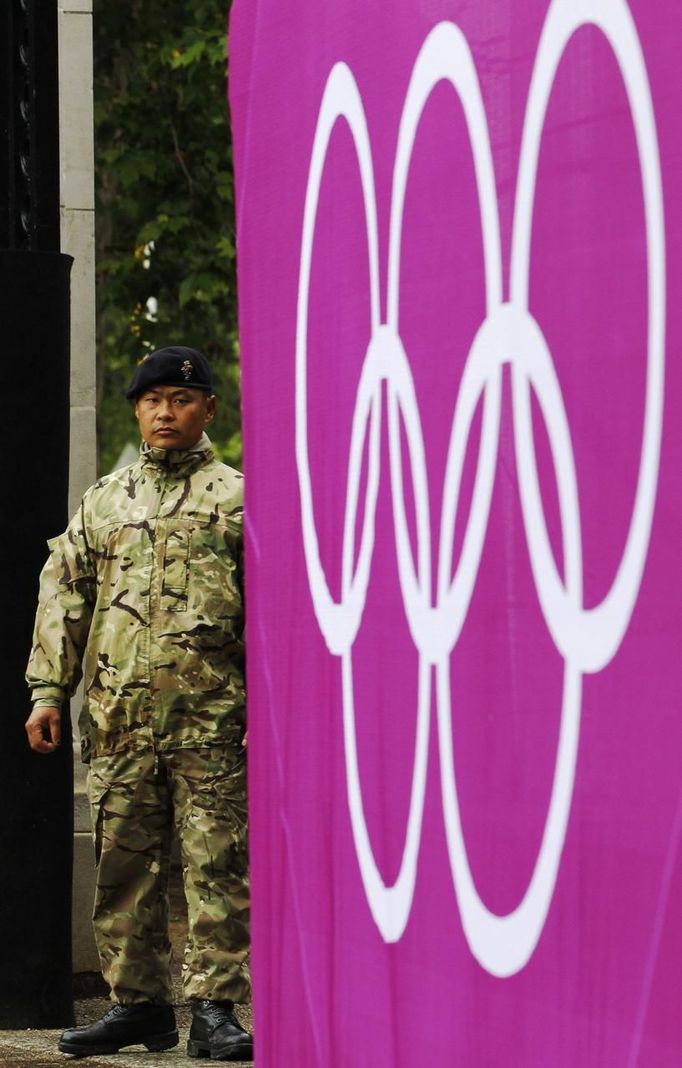 A soldier patrols by a gate at the beach volley ball venue ahead of the London 2012 Olympic Games in London July 16, 2012. The London 2012 Olympic Games start in 11 days time. REUTERS/Luke MacGregor (BRITAIN - Tags: SPORT VOLLEYBALL MILITARY POLITICS OLYMPICS) Published: Čec. 16, 2012, 4:16 odp.