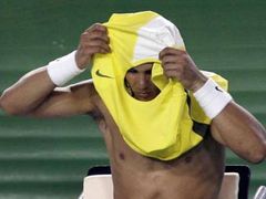 Španělský tenista Rafael Nadal si mění v průběhu zápasu prvního kola Australian Open proti Američanu Kendrickovi propocené tričko.