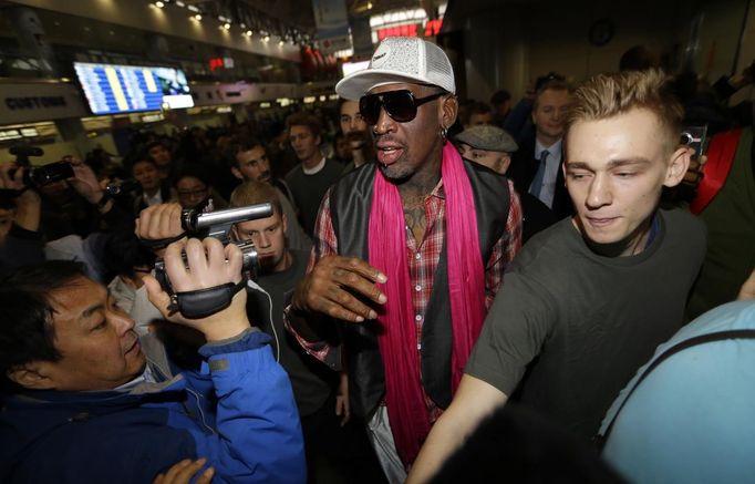 Bývalý basketbalista Dennis Rodman (uprostřed) po příletu na letiště v Pekingu. Odsud zamíří do KLDR. S sebou vzal i další bývalé kolegy z NBA.