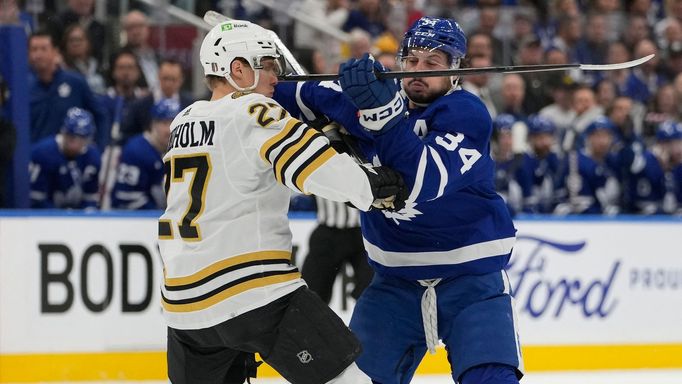 Apr 24, 2024; Toronto, Ontario, CAN; Toronto Maple Leafs forward Auston Matthews (34) and Boston Bruins defenseman Hampus Lindholm (27) battle for position during the fir