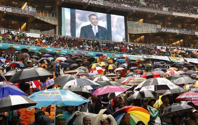 South Africans brave the rain as they listen to U.S. President Barack Obama speak