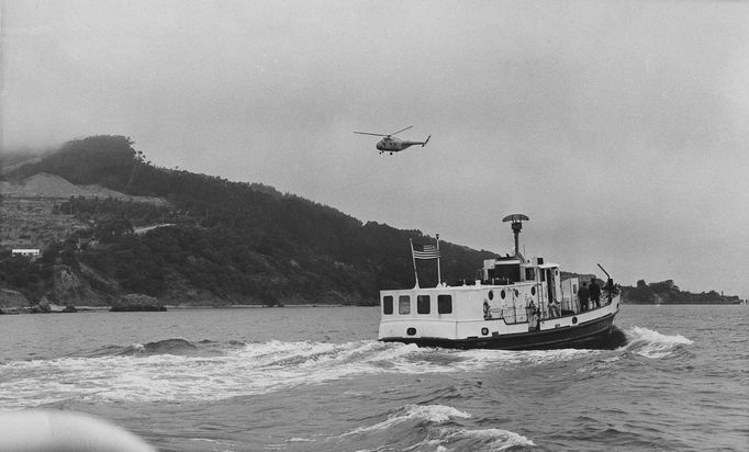 Vrtulník a člun pobřežní stráže USA krouží nad ostrovem Angel Island v Sanfranciském zálivu při pátrání po uprchlých vězních z Alcatrazu., 12. června 1962