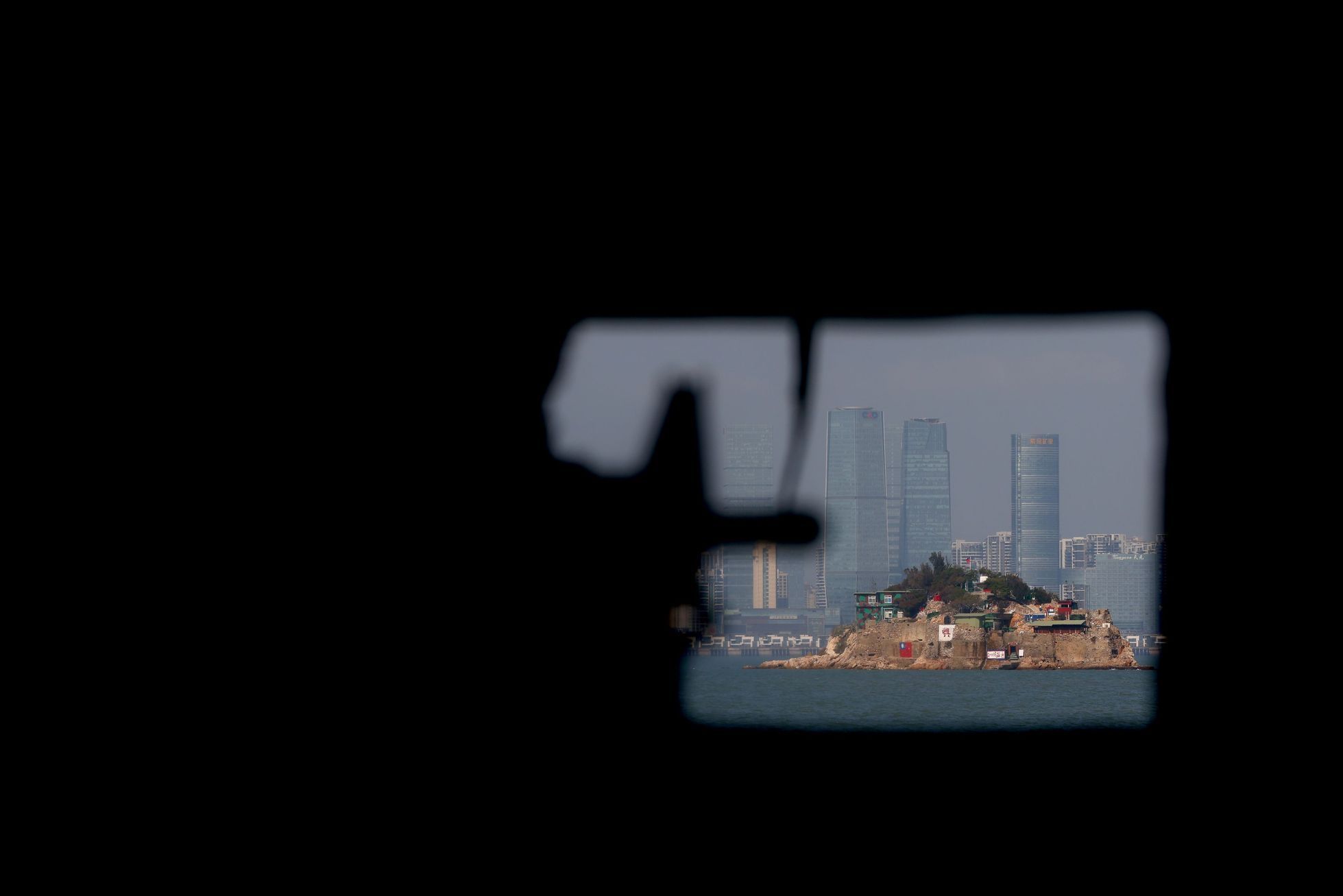 Pohled ze staré střílny na tchajwanském souostroví Ťin-men směrek k městu Sia-men na čínském pobřeží.