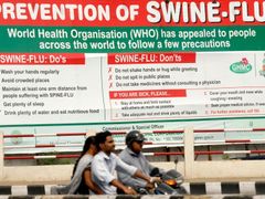 Lidé míjí billboard s návodem, jak nejlépe předcházet nákaze prasečí chřipkou. Snímek pochází z Indie.