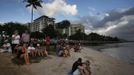 Tourists look at a cloudy sky as a full solar eclipse begins in the northern Australian city of Cairns November 14, 2012. REUTERS/Tim Wimborne (AUSTRALIA - Tags: SOCIETY ENVIRONMENT) Published: Lis. 13, 2012, 9:37 odp.