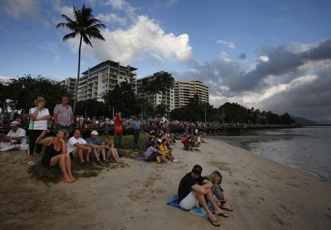 Tourists look at a cloudy sky as a full solar eclipse begins in the northern Australian city of Cairns November 14, 2012. REUTERS/Tim Wimborne (AUSTRALIA - Tags: SOCIETY ENVIRONMENT) Published: Lis. 13, 2012, 9:37 odp.