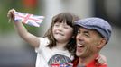 A man holding a girl waving a Union flag stands among other spectators near Parliament Square for a glimpse of Queen Elizabeth in London June 5, 2012. Four days of nationwide celebrations during which millions of people have turned out to mark the Queen's Diamond Jubilee conclude on Tuesday with a church service and carriage procession through central London. REUTERS/Kevin Coombs (BRITAIN - Tags: ROYALS SOCIETY) Published: Čer. 5, 2012, 1:29 odp.