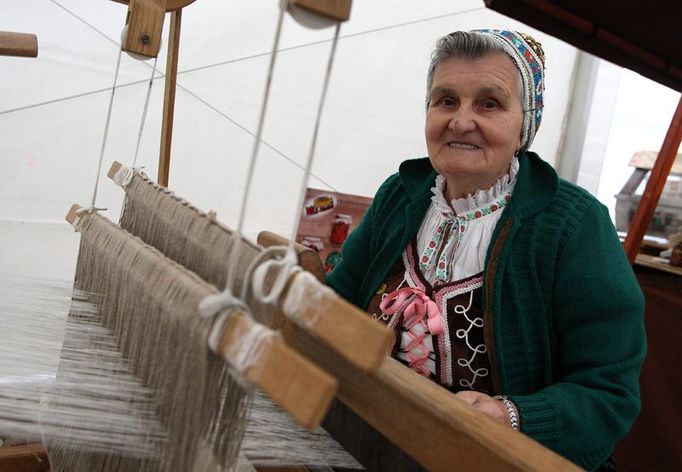 Mária Tomisová u tkalcovského stavu na jarmarku pod stanem.