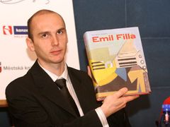 Martin Karas, zástupce sponzora ceny Magnesia Litera, představuje novinářům knihu Emil Fila, která je nominována v kategorii za naučnou literaturu.