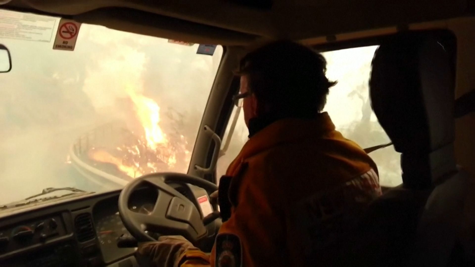 Hasiči utíkají před požárem v Austrálii