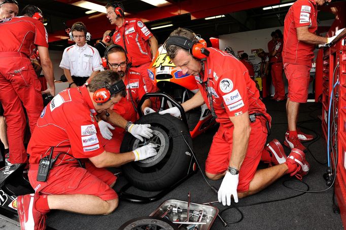 Motocykloví mechanici vyměňují kolo Valentinu Rossimu na GP České republiky v Brně 2011.