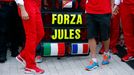 A sign in support of Marussia Formula One driver Jules Bianchi of France is seen among members of Ferrari Formula One team before the first Russian Grand Prix in Sochi Oc