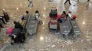 Passengers sit within Barcelona's airport during a protest by cleaning staff May 29, 2012. Cleaning staff working for a company who have a contract with the airport demonstrated against pay and benefits cuts made by their employer. REUTERS/Albert Gea (SPAIN - Tags: CIVIL UNREST BUSINESS TRANSPORT) Published: Kvě. 29, 2012, 5:49 odp.