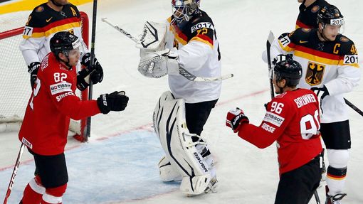 Switzerland's Damien Brunner (R) celebrates his goal with team mate Simon Moser (L) as Germany's goalie Rob Zepp (C) reacts during their men's ice hockey World Championsh