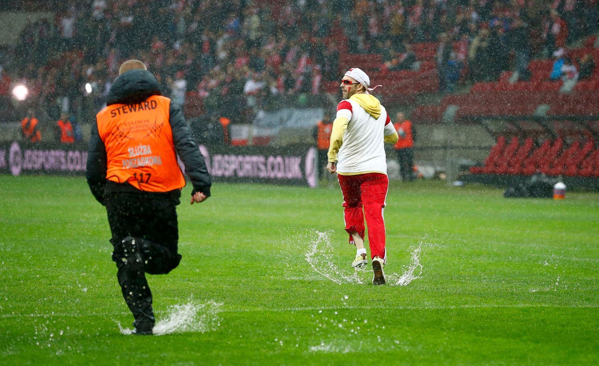 Fanoušci během deště v odloženém utkání Polska s Anglií v kvalifikaci na MS 2014.