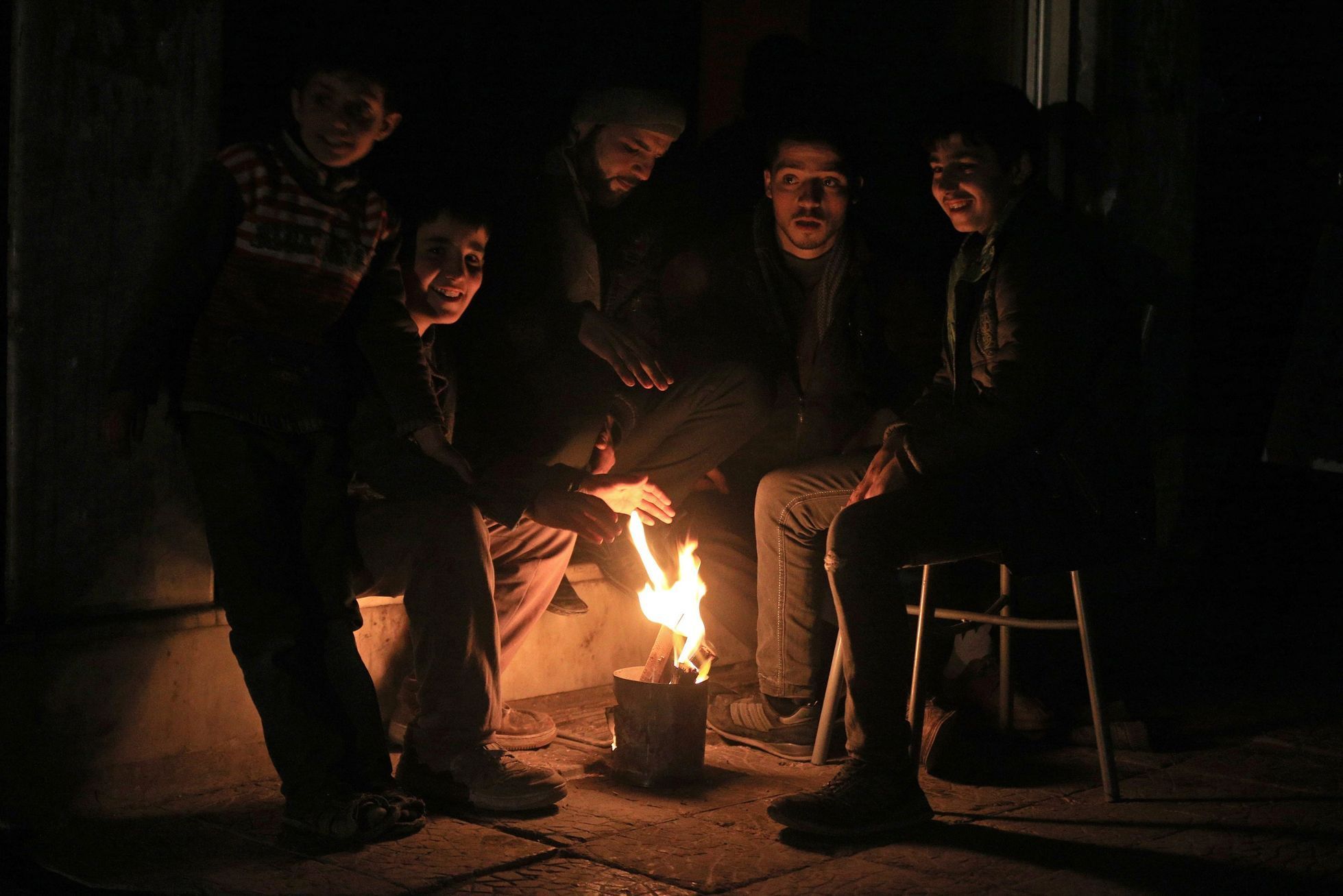 Residents warm themselves by a fire on New Year's Eve in eastern al-Ghouta, near Damascus