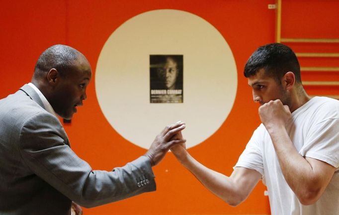 Former Belgian boxing champion Bea Diallo gives instructions to unemployed Mohamed Sammar (R) during a "Fit for a job" boxing class in Brussels July 5, 2013. Sammar, 27, has been looking for a job in the construction sector for 2 years. "Fit for a job" is the initiative of former Belgian boxing champion Bea Diallo, whose goal was to restore the confidence of unemployed people and help them find a job through their participation in sports. Picture taken July 5, 2013. REUTERS/Francois Lenoir (BELGIUM - Tags: SPORT BOXING SOCIETY TPX IMAGES OF THE DAY BUSINESS EMPLOYMENT) Published: Čec. 5, 2013, 4:19 odp.