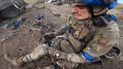 Ukrajinský voják si zaškrcuje nohu po najetí na minu.