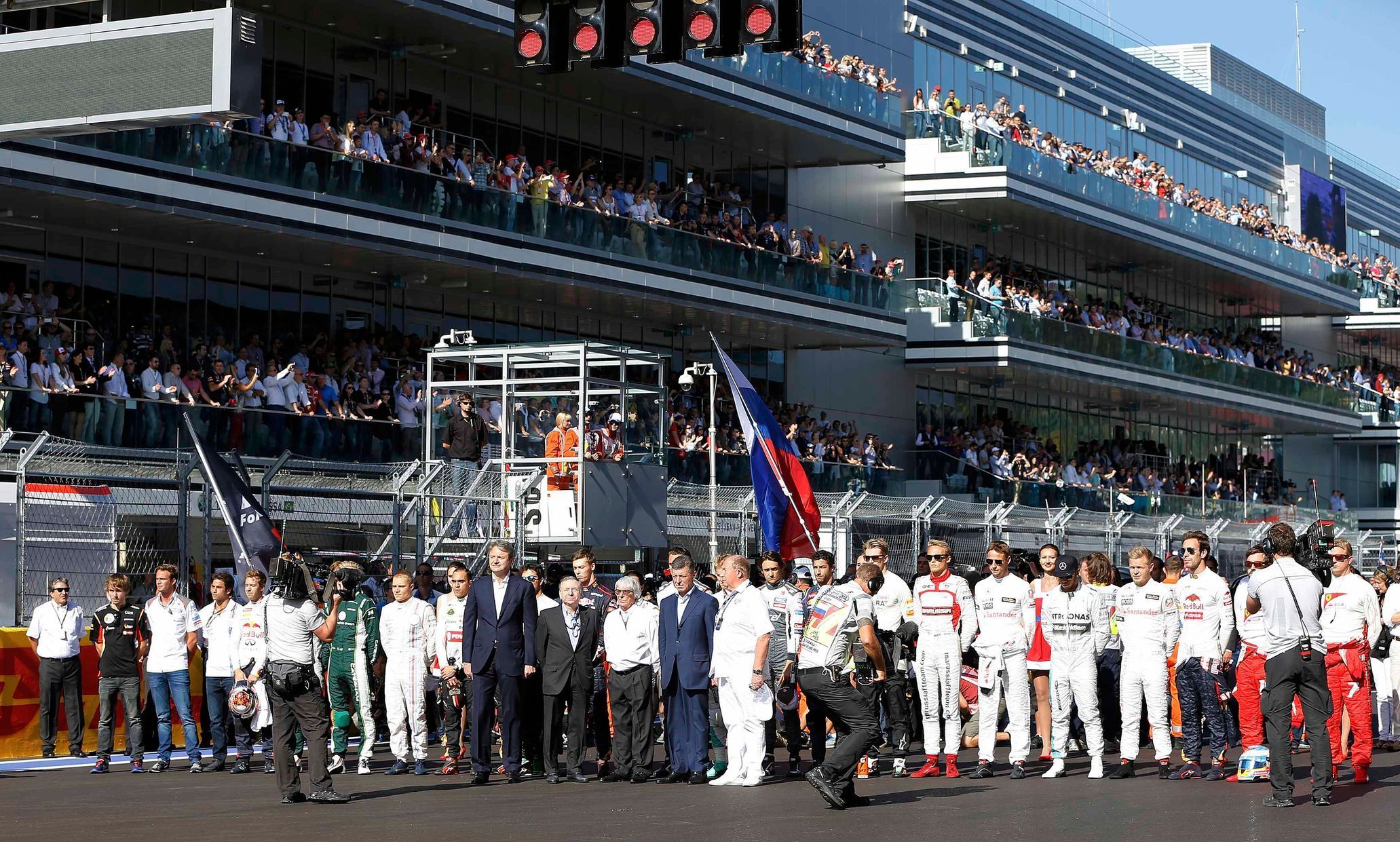 Formula One drivers and officials pray for Marussia Formula One driver Bianchi of France who had an accident in the previous race, before the first Russian Grand Prix in Sochi
