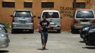 An Australian relative of a victim from the 2002 Bali bombings holds flowers as he walks out of the carpark at Sari Club, which was one of the bombing sites, ahead of the 10th anniversary in Kuta, on the resort island of Bali October 10, 2012. Eighty-eight Australians were among the 202 people killed in the attacks on Sari Club and Paddy's Bar at the popular tourist area of Kuta on October 12, 2002. The graffiti in the background reads, "It is prohibited to urinate here." REUTERS/Beawiharta (INDONESIA - Tags: ANNIVERSARY SOCIETY) Published: Říj. 10, 2012, 5:34 dop.