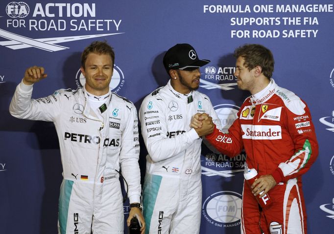 Mercedes F1 driver, Lewis Hamilton of Britain (C) shakes hands with Ferrari F1 Driver, Sebastian Vettel of Germany (R), Nico Rosberg of Germany (L) wave at crowd