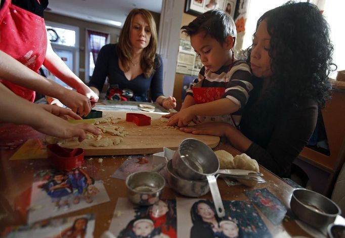 Mercedes Santos (R) and her partner Theresa Volpe help their son Jaidon (2nd R) make cookies at their home in Chicago, Illinois, December 22, 2012. Santos and Volpe are a same-sex couple raising two of their biological children as they struggle to get same-sex marriages passed into law in Illinois. Picture taken December 22, 2012. REUTERS/Jim Young (UNITED STATES - Tags: SOCIETY) Published: Bře. 25, 2013, 6:06 odp.