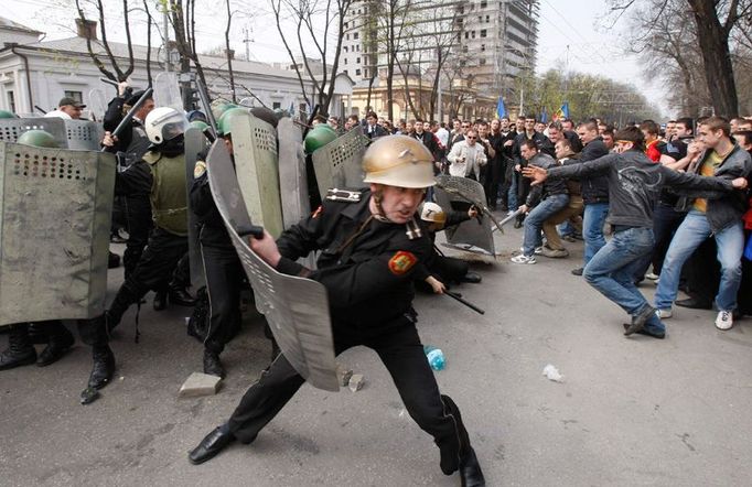 Policejní důstojník odhání demonstranty.