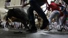 Runners sprint alongside Miura fighting bulls at the Estafeta corner on the the second day of the running of the bulls in Pamplona July 8 2012. Various runners suffered light injuries in a run that lasted two minutes and twenty-eight seconds, according to local media. REUTERS/Joseba Etxaburu (SPAIN - Tags: ANIMALS SOCIETY TPX IMAGES OF THE DAY) Published: Čec. 8, 2012, 8:39 dop.