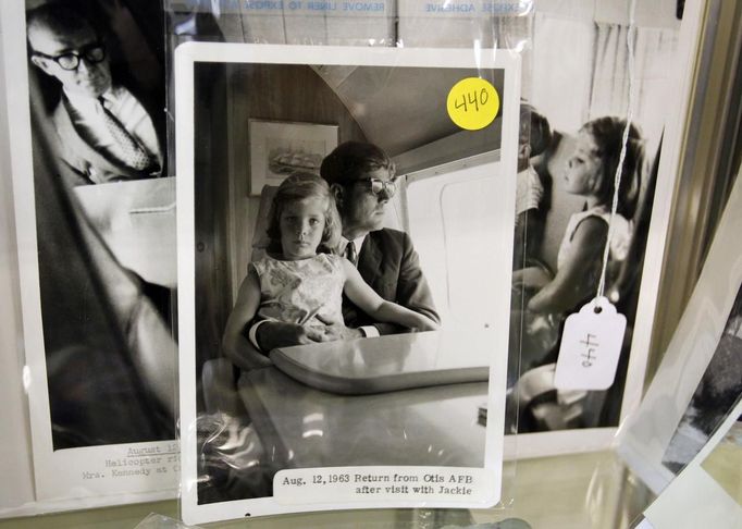 A photo of former U.S. President John F. Kennedy holding his daughter Caroline in 1963 is displayed as part of the McInnis Auctioneers Presidential Auction in Amesbury, Massachusetts February 10, 2013. The auction which features the estate of the late David Powers, special assistant to former president John F. Kennedy, will take place on February 17. REUTERS/Jessica Rinaldi (UNITED STATES - Tags: POLITICS ENTERTAINMENT BUSINESS) Published: Úno. 10, 2013, 9:31 odp.