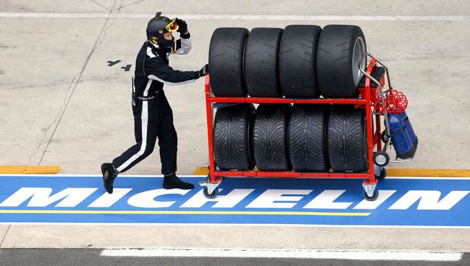 A mechanic transports tyres made by French tyre manufacturer Michelin as he works on the racing circuit during the Le Mans 24-hour sportscar race in central France, June