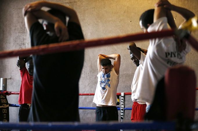 Unemployed Belgian Mohamed Sammar stretches as he takes part in a "Fit for a job" boxing class in Brussels June 14, 2013. Sammar, 27, has been looking for a job in the construction sector for 2 years. "Fit for a job" is the initiative of former Belgian boxing champion Bea Diallo, whose goal was to restore the confidence of unemployed people and help them find a job through their participation in sports. Picture taken June 14, 2013. REUTERS/Francois Lenoir (BELGIUM - Tags: SPORT BOXING SOCIETY BUSINESS EMPLOYMENT) Published: Čec. 5, 2013, 3:57 odp.