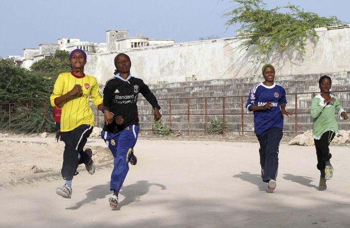 Somali athletes run inside the Koonis stadium as they train during preparations for the 2012 London Olympic Games in Somalia's capital Mogadishu in this March 14, 2012 file photo. Training in a bullet-riddled stadium where the remains of a rocket propelled grenade lies discarded on the track's edge counts as progress for Somali Olympic hopeful Mohamed Hassan Mohamed. A year ago, Mogadishu's Konis stadium was a base for Islamist militants and a work out meant at times running through the streets, dodging gun-fire and mortar shells in one of the world's most dangerous cities. Picture taken March 14, 2012. To match OLY-SOMALIA-HOPES/ REUTERS/Feisal Omar/Files (SOMALIA - Tags: SPORT ATHLETICS SOCIETY OLYMPICS) Published: Čer. 11, 2012, 7:11 dop.