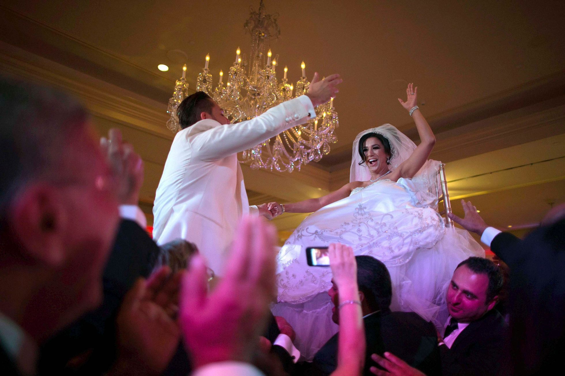 Moshar, who is of Persian, German and Filipino descent, dances with her husband Safar, whose parents are from Syria, as they are both lifted into the air during their wedding reception in Pasadena