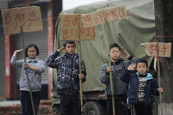 Children salute passing vehicles carrying rescuers and volunteers as they hold cardboards with messages of gratitude, after Saturday's earthquake, in Lushan county, Sichuan province April 23, 2013. The earthquake killed 192 people, left 23 missing, and injured more than 11,000, state media said. REUTERS/Stringer (CHINA - Tags: DISASTER ENVIRONMENT) Published: Dub. 23, 2013, 2:52 odp.