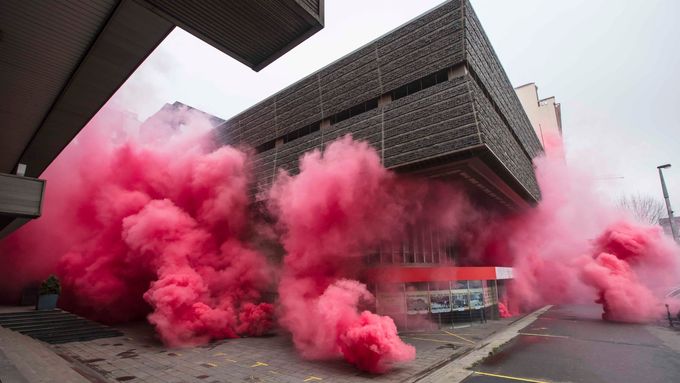 Budova Transgasu se zahalila do růžového dýmu. Umělecká skupina tak bojuje proti bouráni