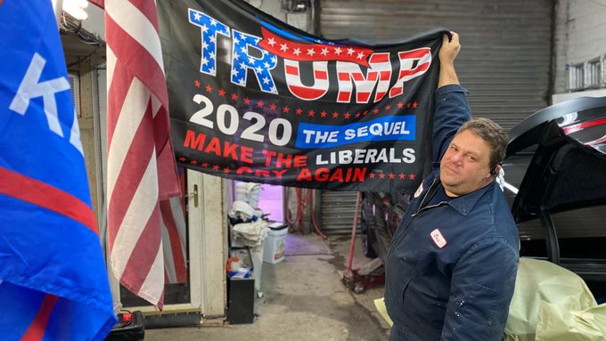 Eric Nocera s transparentem Donalda Trumpa ve svém autoservisu v Brooklynu. Podnikatel stále věří, že jeho favorit zůstane i po lednové inauguraci v Bílém domě.