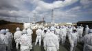 Members of the media wearing protective suits and masks are escorted by TEPCO employees at Tokyo Electric Power Co. (TEPCO)'s tsunami-crippled Fukushima Daiichi nuclear power plant in Fukushima prefecture in this February 20, 2012 file photo. Decommissioning Japan's tsunami-devastated Fukushima Daiichi nuclear plant will take decades, require huge injections of human and financial capital and rely on yet-to-be developed technologies. To match Insight JAPAN-FUKUSHIMA/ REUTERS/Issei Kato/Files (JAPAN - Tags: DISASTER ENVIRONMENT BUSINESS POLITICS) Published: Bře. 5, 2013, 10:25 odp.