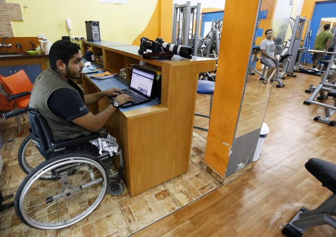 Wheelchair-bound Palestinian freelance photographer Moamen Qreiqea uses a laptop computer at a gym in Gaza City October 1, 2012. Qreiqea, 25, lost both his legs in an Israeli air strike in 2008 while taking pictures east of Gaza. The father of two is determined to continue his career despite his disability. REUTERS/Suhaib Salem (GAZA - Tags: MEDIA SOCIETY) Published: Říj. 1, 2012, 3:39 odp.