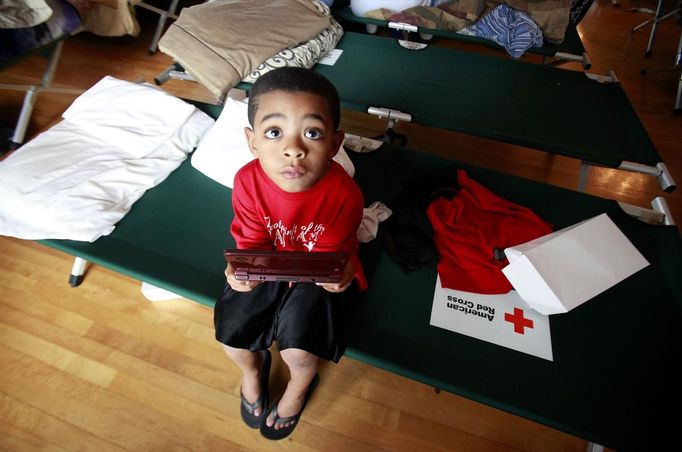 Jaylon Ragas, 5, plays with a gaming device at the Belle Chase Auditorium as Hurricane Isaac bears down on the Louisiana coast in Belle Chasse, Louisiana, August 28, 2012. REUTERS/Sean Gardner (UNITED STATES - Tags: ENVIRONMENT DISASTER) Published: Srp. 28, 2012, 8:14 odp.