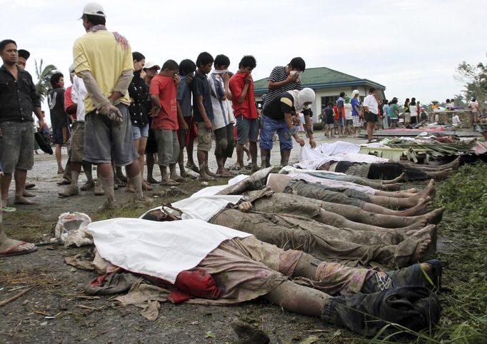 Bodies of flash flood victims lie on the ground as villagers look for their missing relatives after Typhoon Bopha hit New Bataan in Compostela province, southern Philippines December 5, 2012. Bopha, the Philippines' strongest typhoon this year, was headed towards tourist destinations on Wednesday after hitting a southern island, destroying homes, causing landslides and killing at least 82 people, but many more are reported dead and missing. REUTERS/Stringer(PHILIPPINES - Tags: DISASTER ENVIRONMENT TPX IMAGES OF THE DAY) Published: Pro. 5, 2012, 5:48 dop.