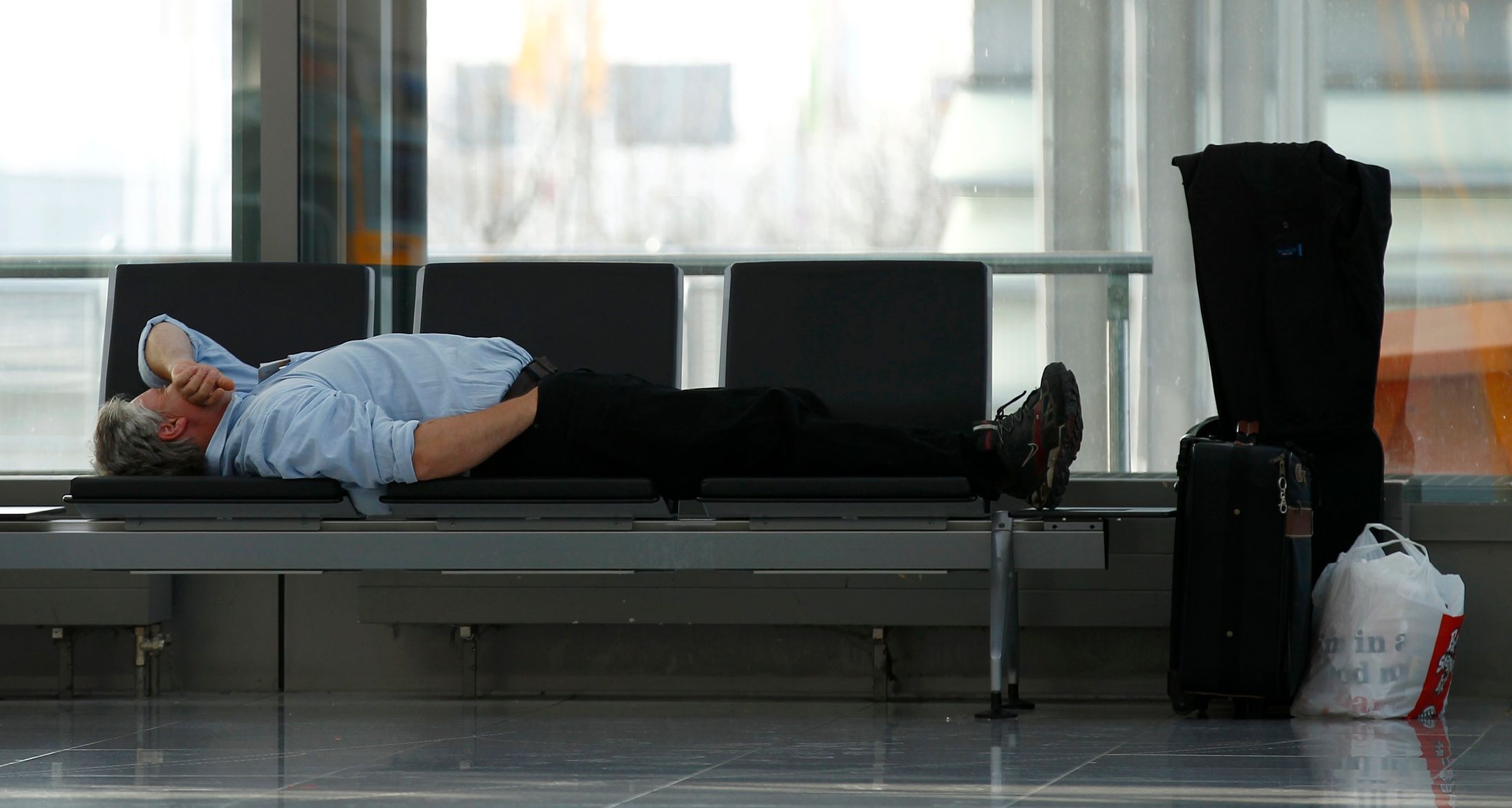 Passenger rests while waiting for his Lufthansa flight at Munich's airport