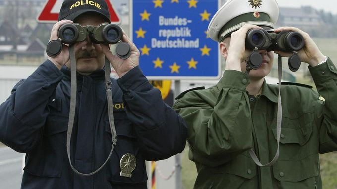 File picture shows Petr Wolf (L) a Czech Republic's border police officer and his German counterpart Marcel Pretzsch as they watch the German-Czech unguarded border zone near the German village of Zinnwald, around 40 kilometres south of Dresden April 23, 2004.