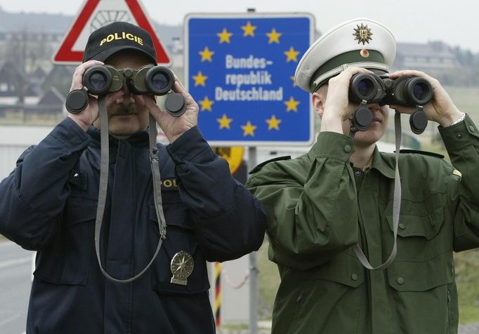 File picture shows Petr Wolf (L) a Czech Republic's border police officer and his German counterpart Marcel Pretzsch as they watch the German-Czech unguarded border zone near the German village of Zinnwald, around 40 kilometres south of Dresden April 23, 2004.