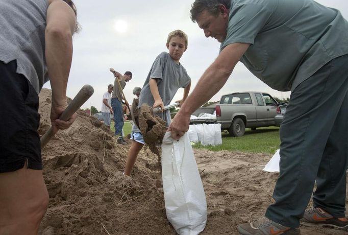 Nine-year-old Jaydon Charrier (center), fills sandbags with his parents at local government sandbag distribution pointas they prepare for the arrival of Tropical Storm Isaac in Chauvin. Louisiana August 27, 2012. REUTERS/Lee Celano (UNITED STATES - Tags: ENVIRONMENT DISASTER) Published: Srp. 28, 2012, 12:03 dop.