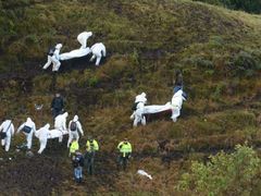 Záchranáři odnáší oběti pádu letadla, které havarovalo v Kolumbii.